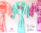 Colorful tie-dye bride and bridesmaid robes with "Bride" and "Bride Tribe" prints, perfect for wedding parties.